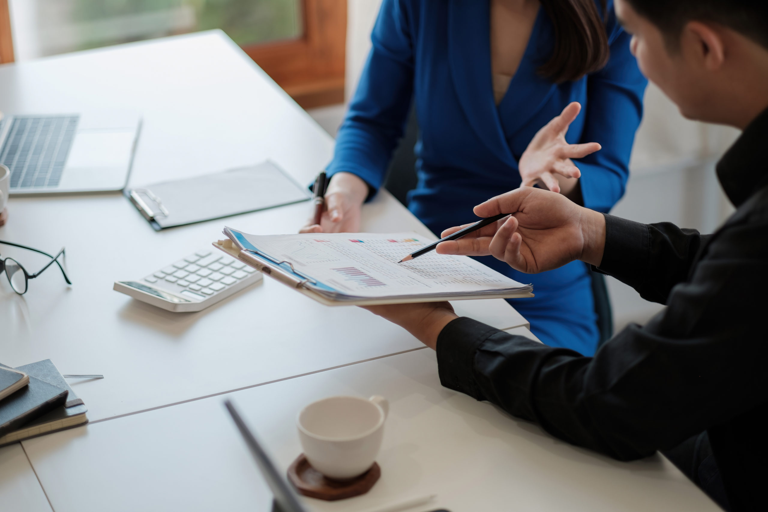 Two colleagues discussing data with document data on desk table. Close up business people meeting to discuss the situation on the market.